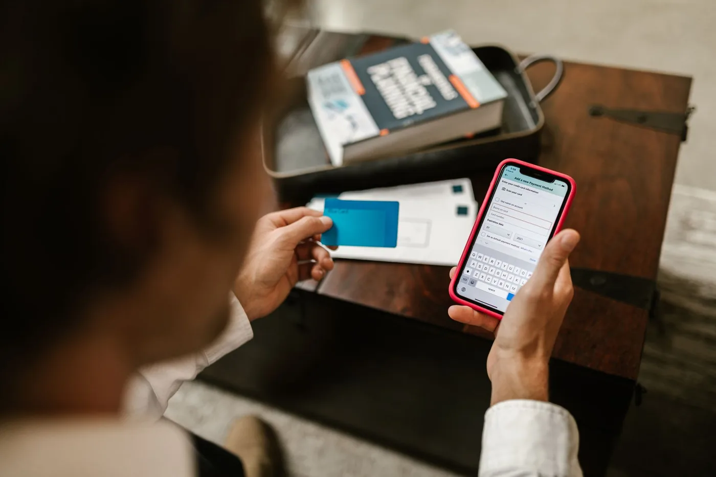 Muž s kartou a bankovní aplikací v telefonu
