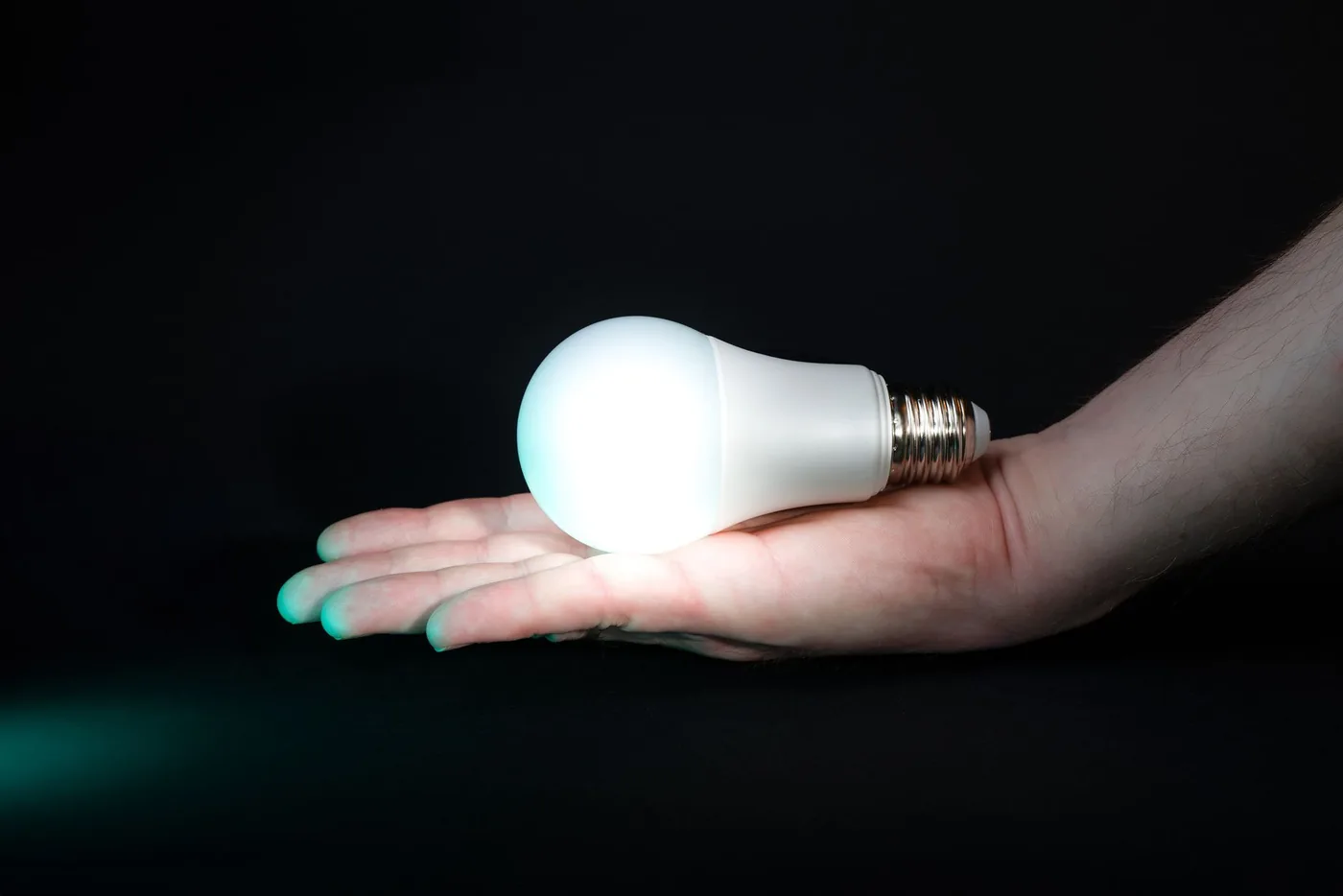 Ruka držící svítící LED žárovku