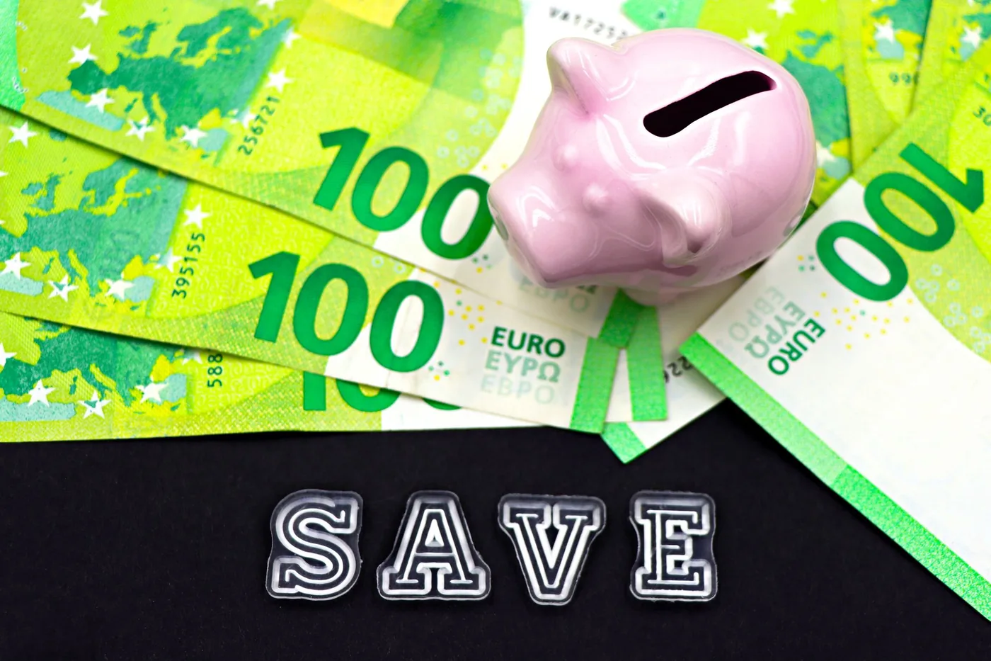 prasátko pokladnička na eurových bankovkách s nápisem SAVE