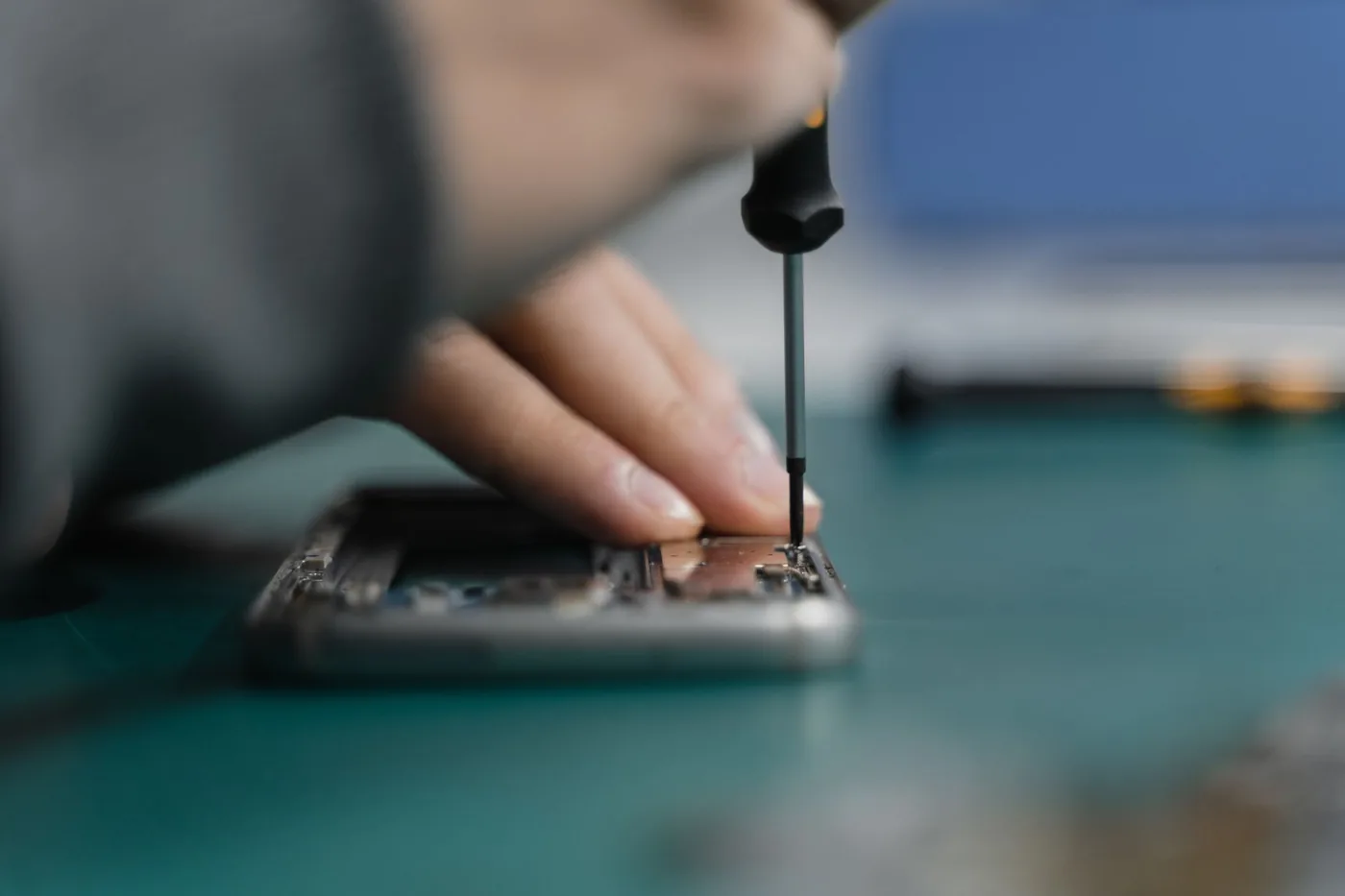 Oprava telefonu šroubovákem na pracovním stole
