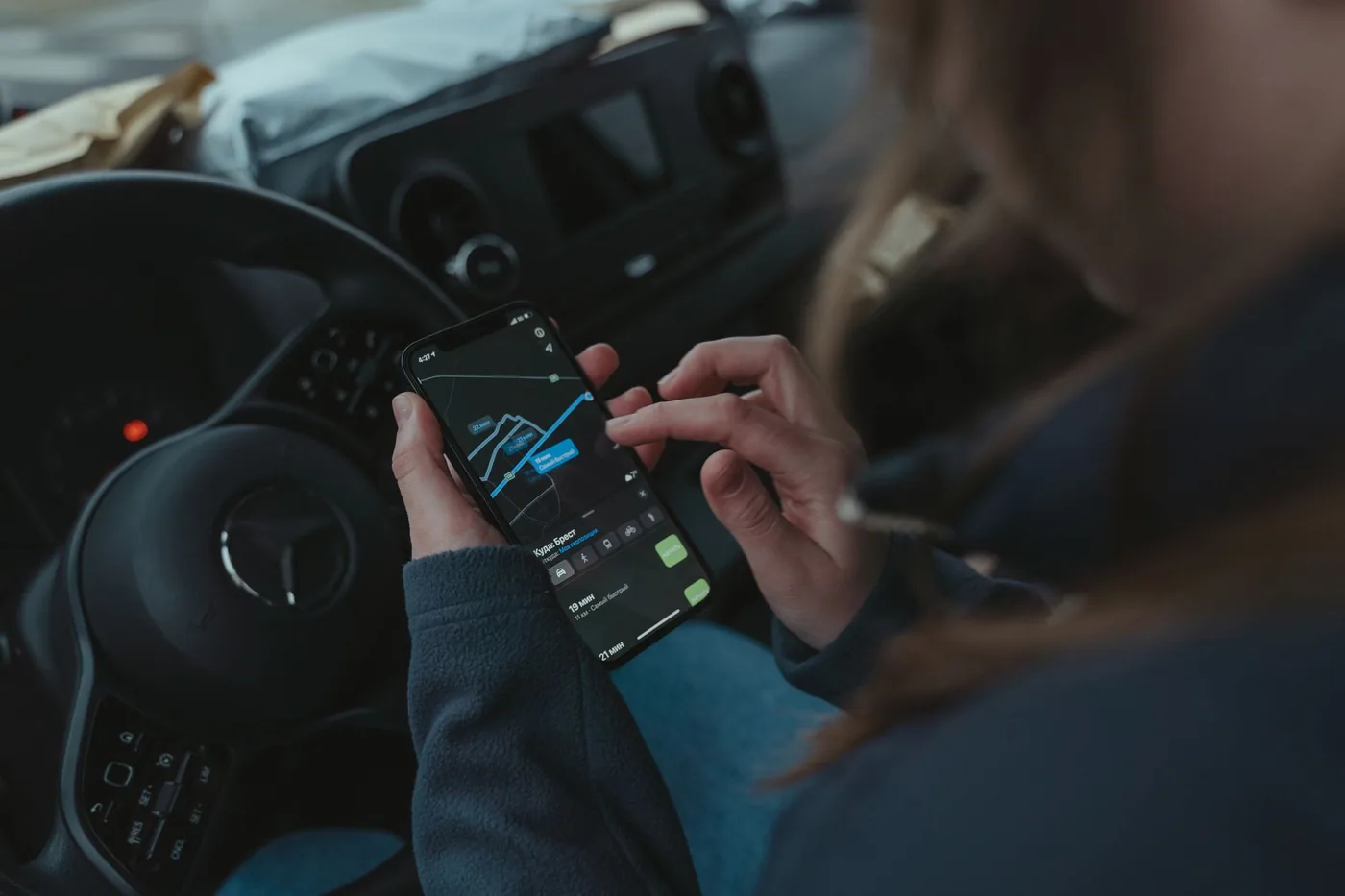 Žena používá aplikaci na telefonu v autě