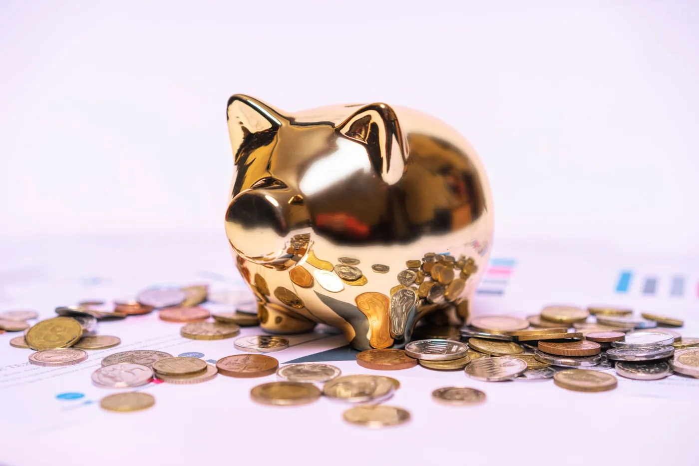 Zlatá pokladnička s mincemi na finančních dokumentech